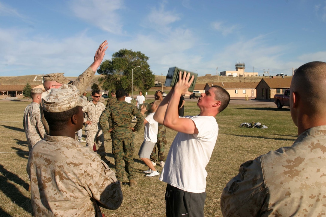 Marines with 2nd Air-Naval Gunfire Liaison Company, II Marine Expeditionary Force, give teens from the National Guard Youth Challenge Program a combat fitness test aboard Camp Guernsey Army Air Field, Wyo., recently. The exercise involved a two minute maximum set of 30-pound ammo-can shoulder presses and finish with a maneuver under fire course.