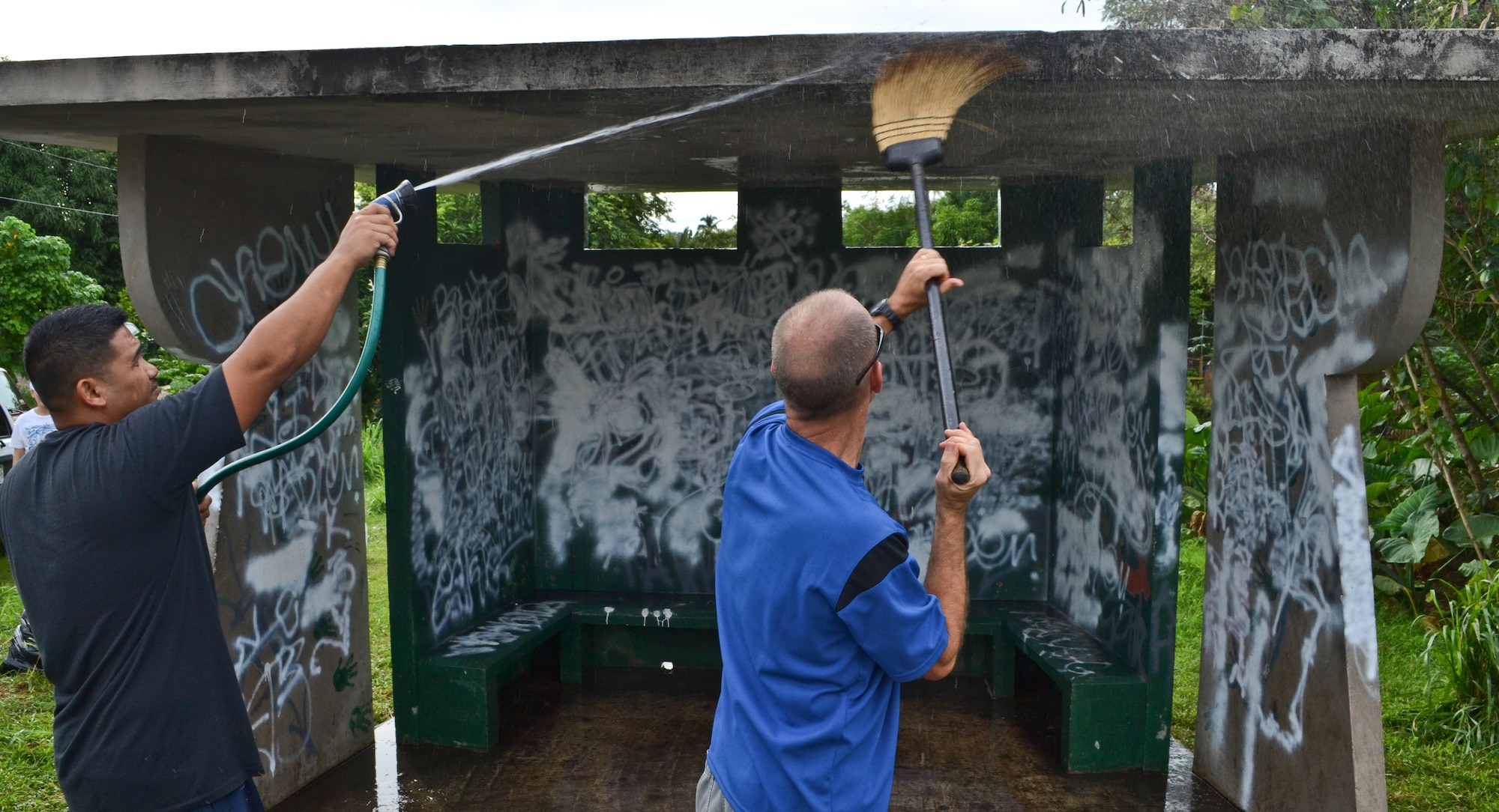 Airmen from the 36th Maintenance Squadron wash off dirt and old paint prior to repainting a bus stop for an Island Beautification project in Mangilao, Guam Oct 15.  Throughout the year, squadrons from Andersen AFB volunteer their time to help clean, repair and build areas in Guam communities in support of the Islandwide Beautification Task Force. (U.S. Air Force photo by Staff Sgt. Alexandre Montes/RELEASED) 