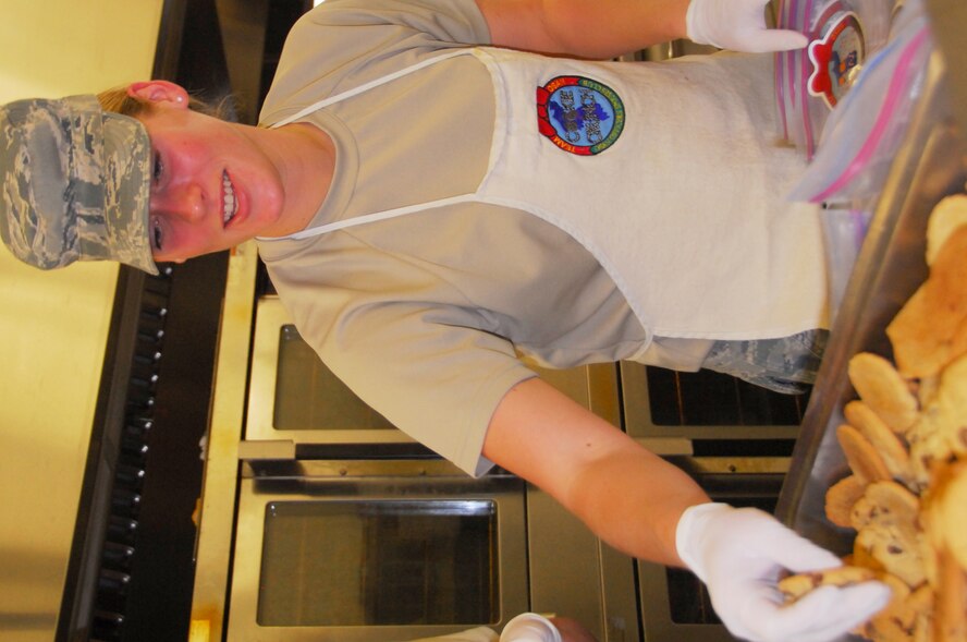 Airman 1st Class Rachel Bogard, 303rd Intelligence Squadron, selects Oct. 20, 2011, a mix of sugar and chocolate chip cookies during the afternoon "Cookie Crunch" baking shift. These cookies are for unaccompanied military people stationed in Korea and deliveries will be made sometime between Thanksgiving and Christmas. This "Cookie Crunch" is a holiday cheer project of the Osan Air Base Officer Spouses Club.  (Air Force photo by Senior Master Sgt. Stuart Camp)