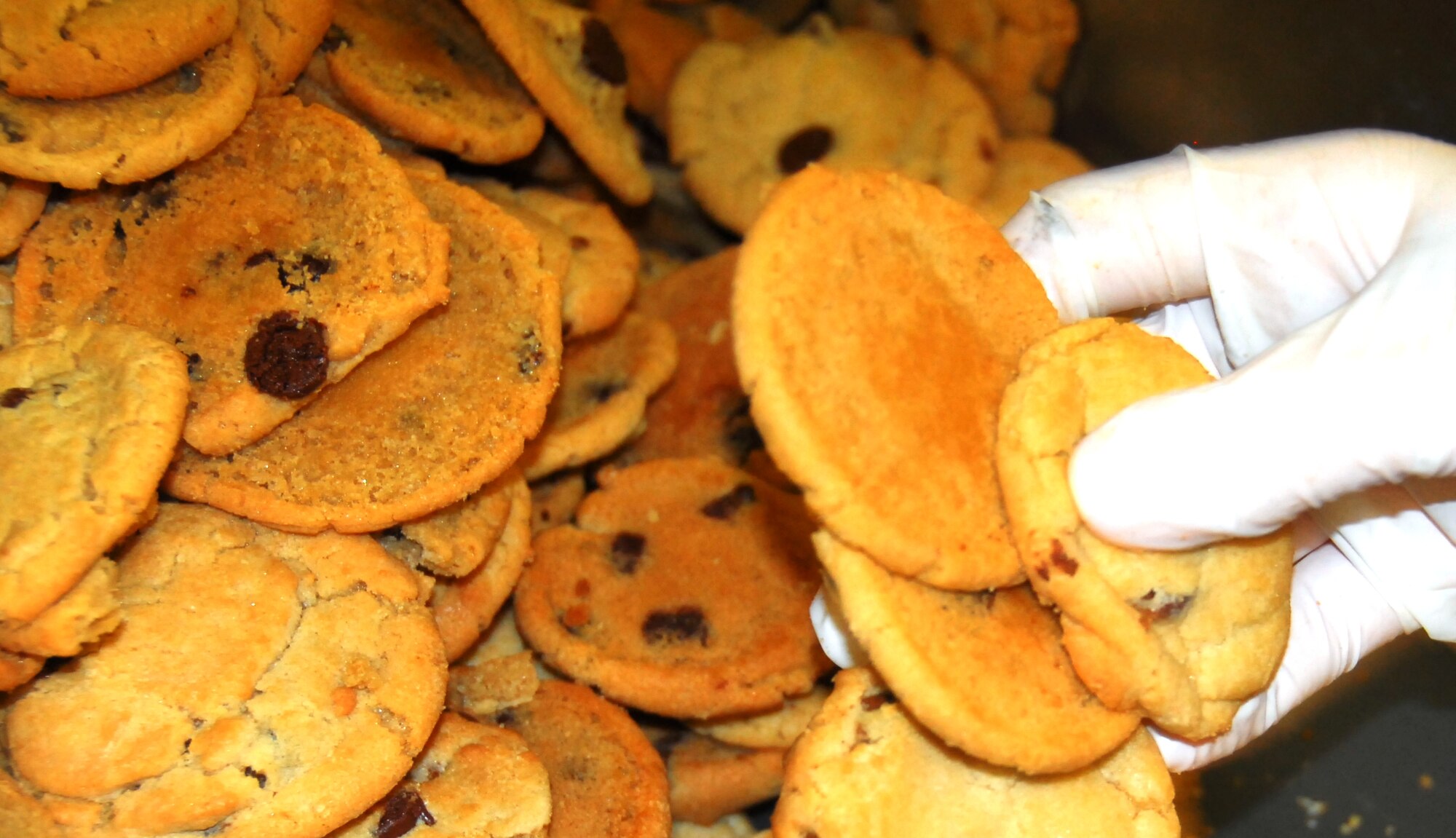 Cassidy Johns, spouse of Capt Chris Johns, 25th Fighter Squadron, sorts out sugar and chocolate chip cookies for each "Cookie Crunch" bag Oct. 20, 2011.  The Osan Air Base Officer Spouses Club is baking 76,000 cookies more than 9,000 unaccompanied military people on the Korean peninsula.  (Air Force photo by Senior Master Sgt. Stuart Camp)