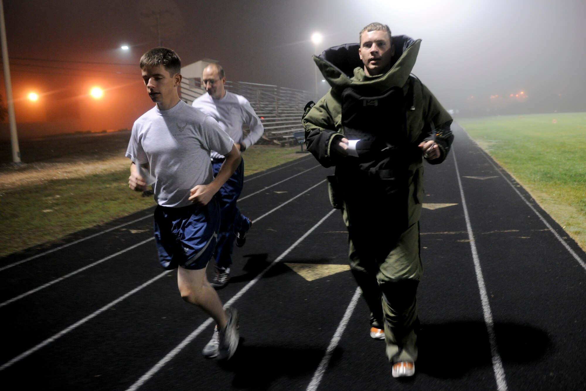 VANDENBERG AIR FORCE BASE, Calif. -- Staff Sgt. Stephen Ohge, right, a 30th Civil Engineer Squadron explosive ordnance disposal team leader, runs in a bomb suit during the base's A Run to Remember event at the Vandenberg track Thursday, Oct. 20, 2011. Sergeant Ohge's goal is to run 100 miles during A Run to Remember, an event to honor all servicemembers who lost their lives in support of Operation Iraqi Freedom, Operation Enduring Freedom and Operation New Dawn. (U.S. Air Force Photo/Staff Sgt. Levi Riendeau)
