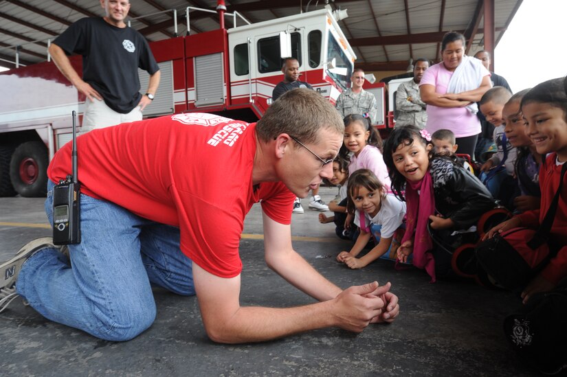 Tech. Sgt. Joseph Nix, 612th ABS assistance chief of fire prevention, teaches local kindergarten children to stay low when encountering smoke Oct. 19, 2011, at Soto Cano Air Base, Honduras. Airmen from the 612th Air Base Squadron’s fire department provided fire safety training to more than 95 local kindergarten children during fire prevention week. (U.S. Air Force photo/Tech.Sgt. Matthew McGovern)