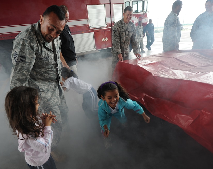 Airmen from the 612th Air Base Squadron’s fire department help children crawl through a simulator containing dry ice smoke as part of fire safety training Oct. 19, 2011, at Soto Cano Air Base, Honduras. Other activities included a smoke detector class, fire station tour and water truck demonstration. (U.S. Air Force photo/Tech. Sgt. Matthew McGovern)

 