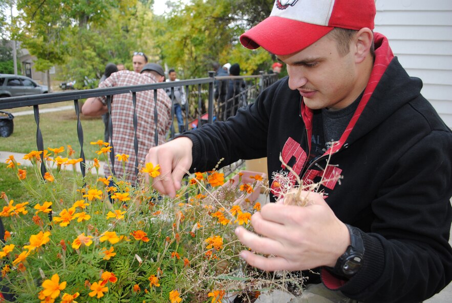 Airman 1st Class Thomas Halley, 741st Missile Security Forces Squadron security escort team guard, pulls weeds from a pot of flowers.  Halley was one of more than 250 volunteers who showed up to participate in the Day of Caring Oct. 14.  (U.S. Air Force photo/Airman Cortney Paxton)