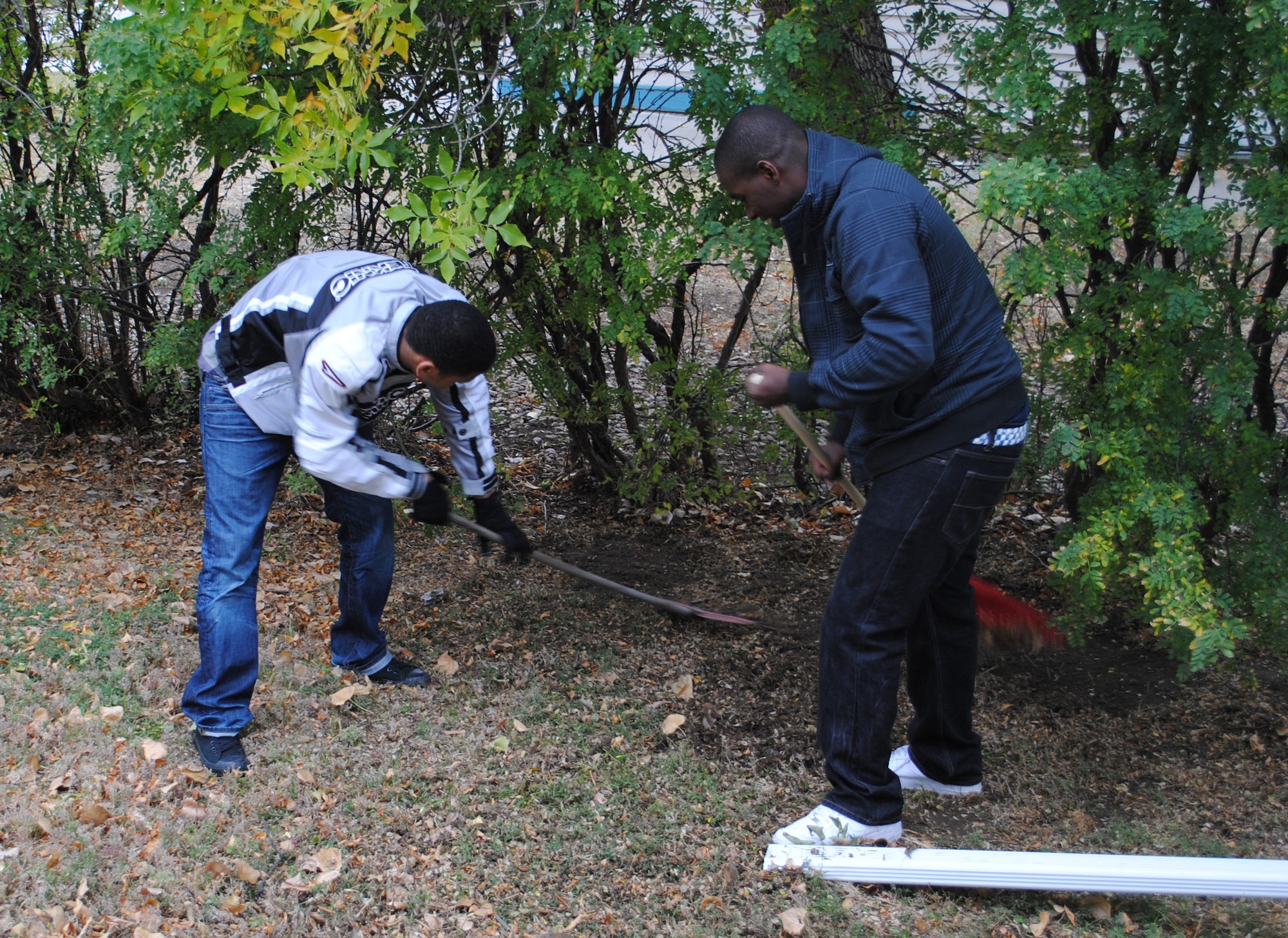 Airmen 1st Class Keith Adams and David Byrd, both security escort team leaders with the 741st Missile Security Forces Squadron, rake leaves from under trees during the Day of Caring Oct. 14.  (U.S. Air Force photo/Airman Cortney Paxton)