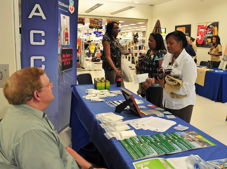 Robert Montgomery, 23rd Civil Engineer Squadron energy manager, hands out energy conservation tips to Theresa Allen, 23rd Force Support Squadron human resources specialist, right, and Wonda Todd, 23rd FSS civilian personnel office, at the Energy Conservation Month booth inside the Exchange on Moody Air Force Base, Ga., Oct. 18, 2011. October has been observed as the Energy Conservation Month by the government, local businesses and concerned citizens for more than 15 years.  These organizations provide activities and programs for the public while promoting energy awareness. (U.S. Air Force photo by Staff Sgt. Stephanie Mancha/Released)