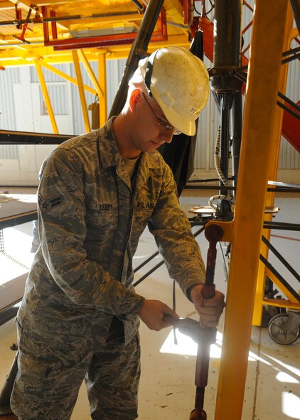 Airman 1st Class Brian Lebby, 317th Maintenance Squadron, tightens down the legs of a platform Oct. 19, 2011 while preparing for a C-130 Hercules inspection at Dyess Air Force Base, Texas. Inspections are conducted yearly on C-130s ensuring mission readiness. (U.S. Air Force photo by Airman 1st Class Jonathan Stefanko/ Released)