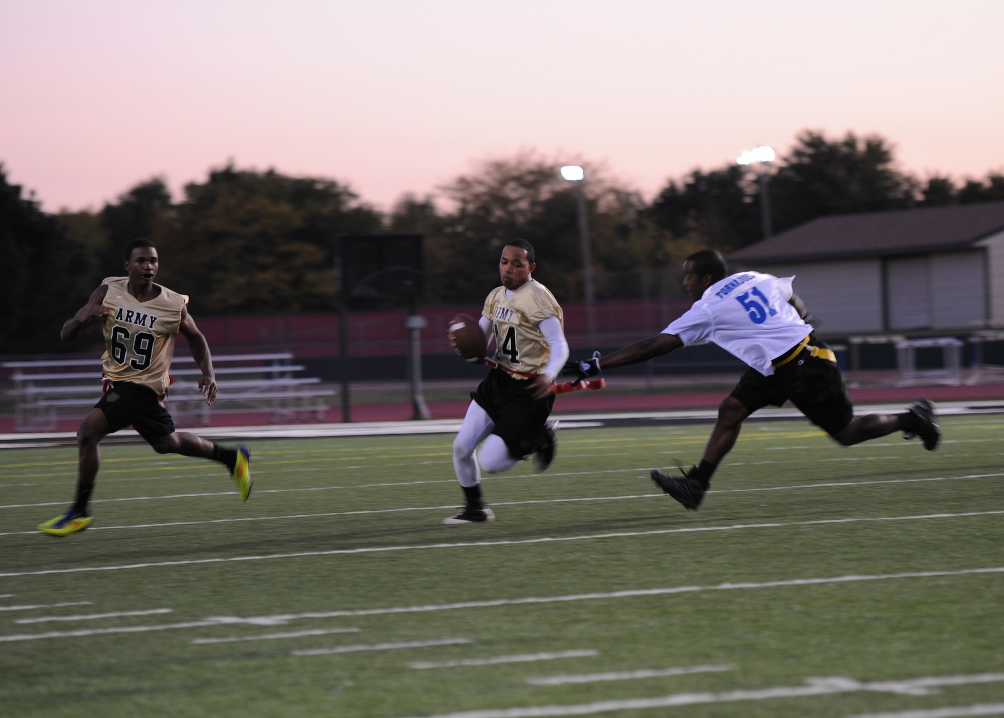 Dan Nickerson, Fort Riley Team quarterback, tries to escape Jerry Hoover, McConnell Team defensive line, during a flag football game at Derby High School, Oct. 15, 2011, Derby, Kan. The Air Force prevailed over Fort Riley 20-18.  (U.S. Air force photo/ Airman 1st Class Maurice Hodges)
