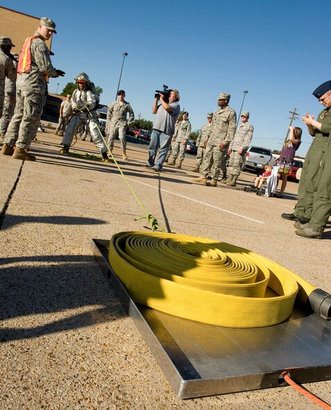 An individual competitor drags a fire hose during the 2nd Bomb Wing Fire Muster on Barksdale Air Force Base, La., Oct. 14. The competition, known as the "backdraft bull", pits individuals against each other in a timed event to complete a strength and endurance course. (U.S. Air Force photo/Senior Airman Chad Warren)(RELEASED)