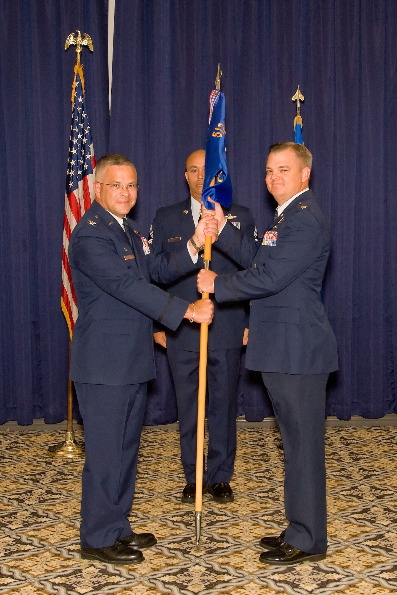 Col. Randal L. Bright, 512th Airlift Wing commander, passes the guidon to Lt. Col. Derin S. Durham who assumed command of the 512th Operations Group here at the Landings, Oct. 16. Durham was accompanied by his parents, Bill and Sue Durham, his wife, Jennifer; and their three children, Savannah, Sarah and Tucker. (U.S. Air Force photo/ Adrian Rowan)