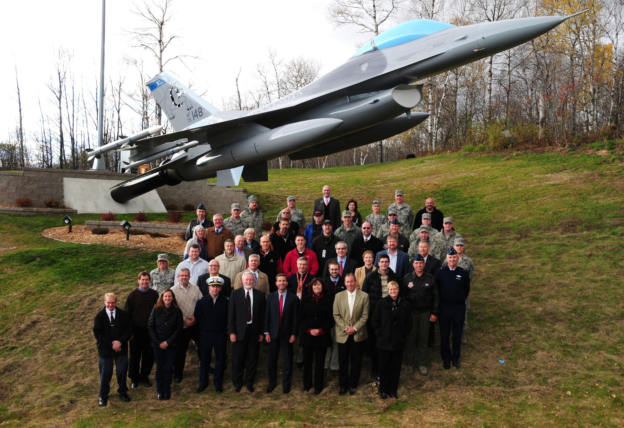 Supporters, Servicemembers and civic leaders pose for a photo following the dedication ceremony of the F-16 static display at the entrance to the 148th Fighter Wing, Oct. 19, 2011. The project was years in the making and made possible by countless hours of labor, materials and more than $100,000 in donated funds from more than 35 local companies and community organizations.  (National Guard photo by Master Sgt. Ralph J. Kapustka.)