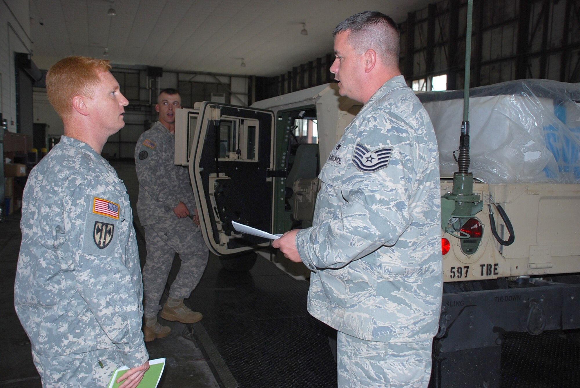 Air Force Tech Sgt. Matthew Marsh (right), 633rd Logistics Readiness Squadron goes over a joint-inspection checklist with Army Warrant Officer Daniel Dryden, brigade mobility warrant officer, 597th Transportation Brigade, during a Joint Assessment Training exercise Oct. 12 at Langley Air Force Base. Soldiers from the 690th Rapid Port Opening Element, 597th Trans. Bde. participated in the exercise, which will help optimize readiness during a pre-flight inspection in the event the unit receives orders to deploy. (U.S. Army photo by Esther Dacanay/RELEASED)