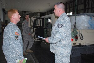 Air Force Tech Sgt. Matthew Marsh (right), 633rd Logistics Readiness Squadron goes over a joint-inspection checklist with Army Warrant Officer Daniel Dryden, brigade mobility warrant officer, 597th Transportation Brigade, during a Joint Assessment Training exercise Oct. 12 at Langley Air Force Base. Soldiers from the 690th Rapid Port Opening Element, 597th Trans. Bde. participated in the exercise, which will help optimize readiness during a pre-flight inspection in the event the unit receives orders to deploy. (U.S. Army photo by Esther Dacanay/RELEASED)