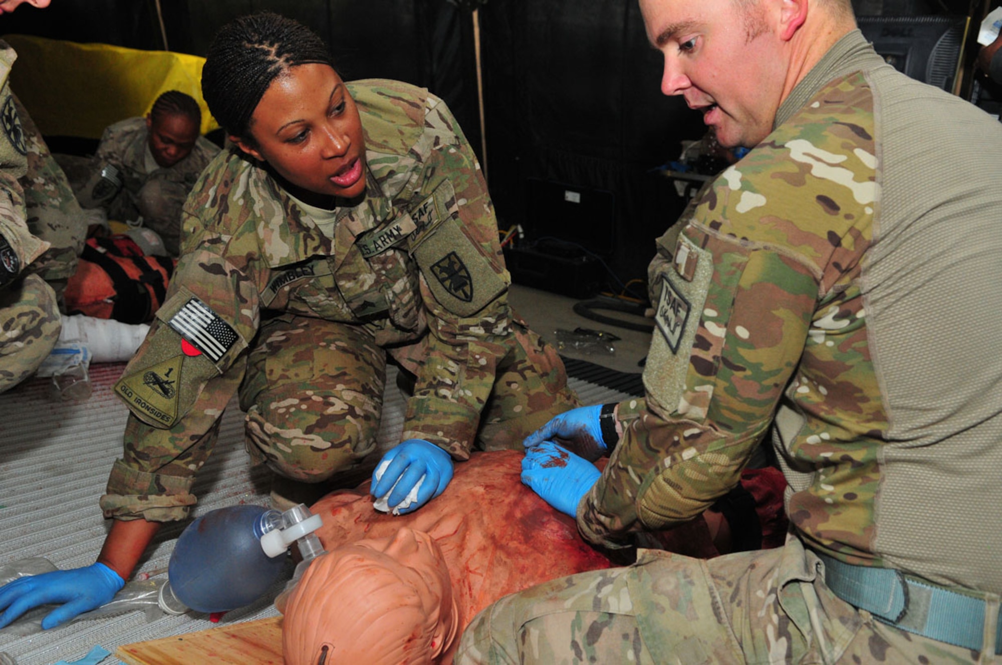 Sgt. Jackeedra Wimbley, left, combat medic with Special Troops Battalion, Task Force Resolute, 7th Sustainment Brigade, works with Senior Airmen John Henry, attached to STB, to assess the simulated injuries of a mannequin during combat medical training at the Medical Simulation Training Center Oct. 8 on Kandahar Airfield, Afghanistan. (U.S. Army photo by Sgt. Edwin J. Rodriguez/RELEASED)