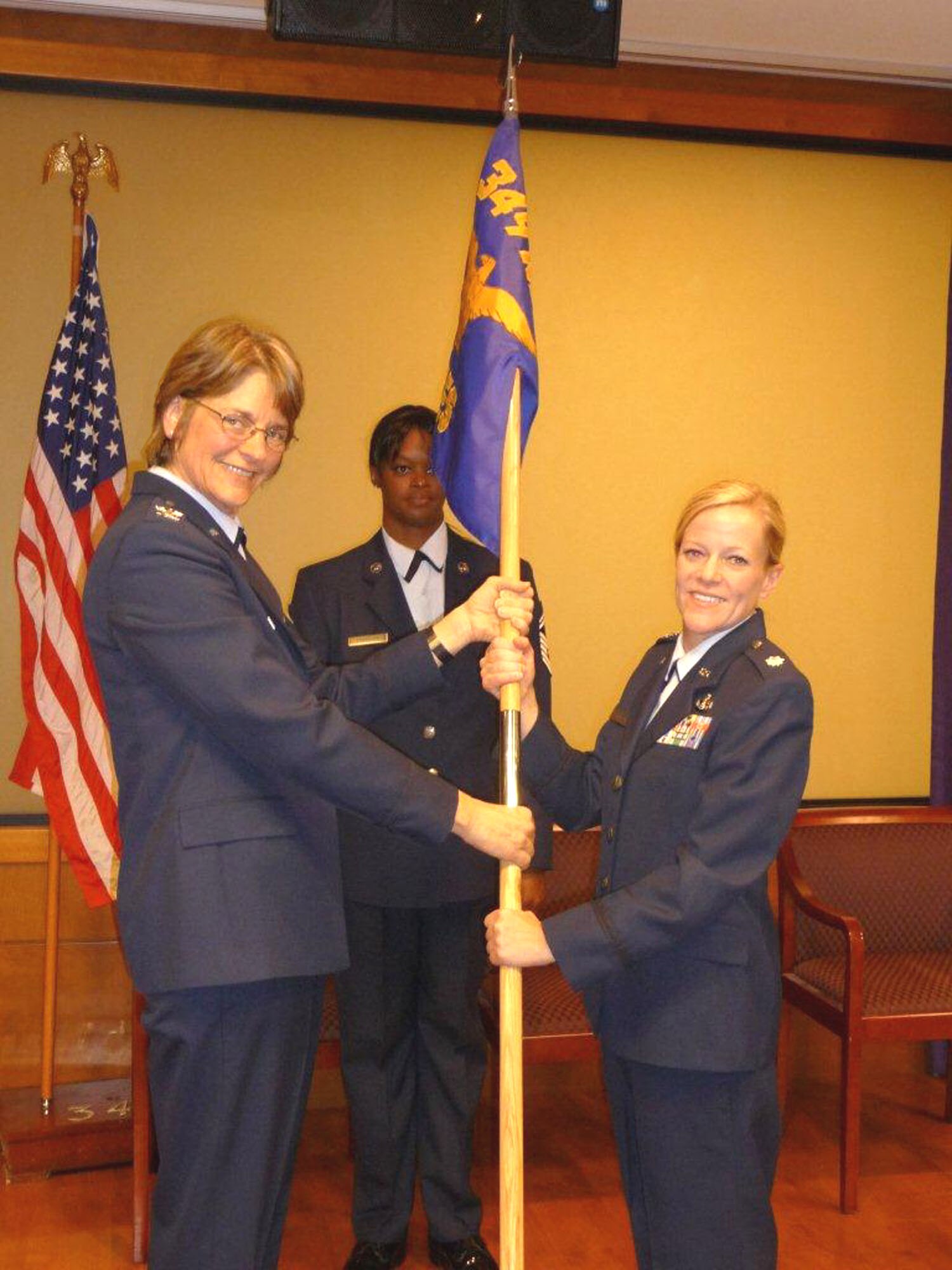 TRAVIS AIR FORCE BASE, Calif. --  Col. Nancy Brooks, Commander, 349th Mission Support Group hands over the squadron flag to Colonel Doolittle, Commander, 349th Civil Engineer Squadron, during a change of command ceremony held on October 15. The new commander also pinned on the rank of Lt. Col. assisted by her father and Col. Brooks. (U.S. Air Force photo by Senior Master Sgt. William M. Faanes)