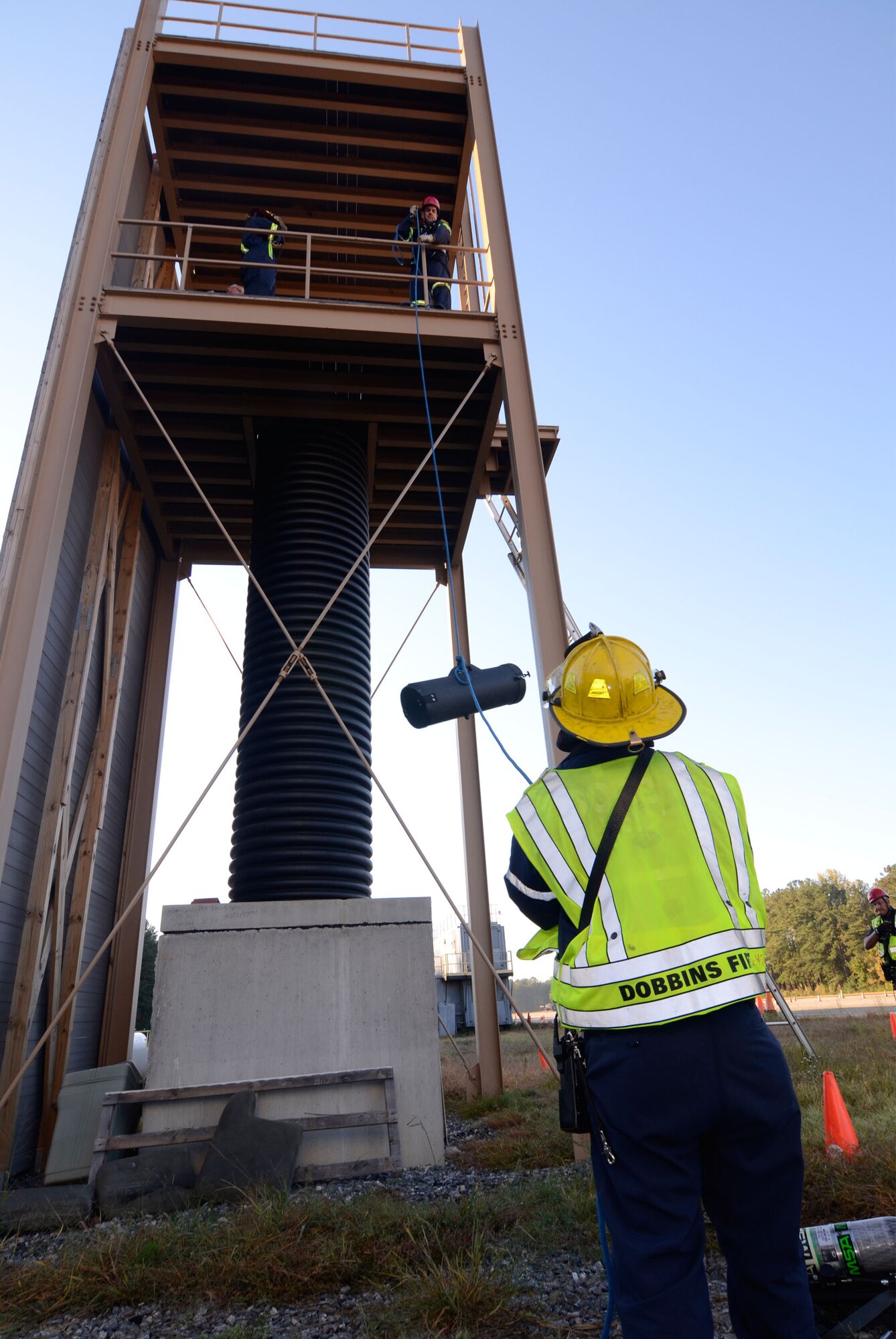Ventilation equipment crucial for rescue is hoisted 30 feet into position by a member of Dobbins Fire Technical Rescue Team during a confined space rescue scenario here Oct. 17. (U.S. Air Force photo/Don Peek)
