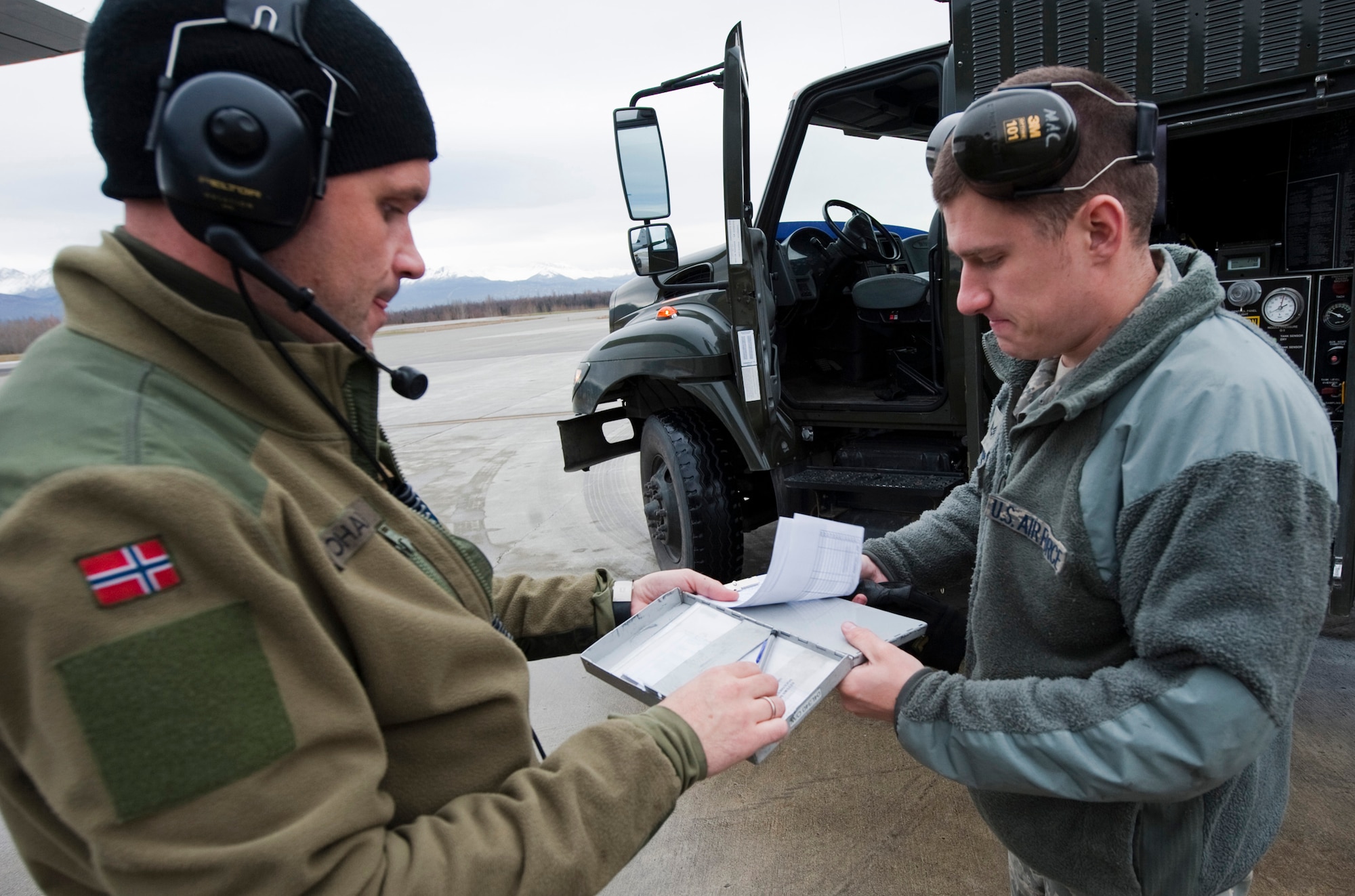 JOINT BASE ELMENDORF-RICHARDSON, Alaska -- Royal Norwegian Air Force Capt. Morten Johansen, 135th Air Wing, Gardermoen Air Station, Norway, receives paperwork from U.S. Air Force Senior Airman Jonathan Macpheron, 673d Logistics Readiness Squadron, after a refuel of RNAF's C-130 Hercules during Red Flag-Alaska Oct. 13. This was the first time the RNAF has participated in RF-Alaska. Twenty-three airmen from the 135th Air Wing participated in the exercise Oct. 6 to Oct. 21. (U.S. Air Force photo/Senior Airman Christopher Gross)