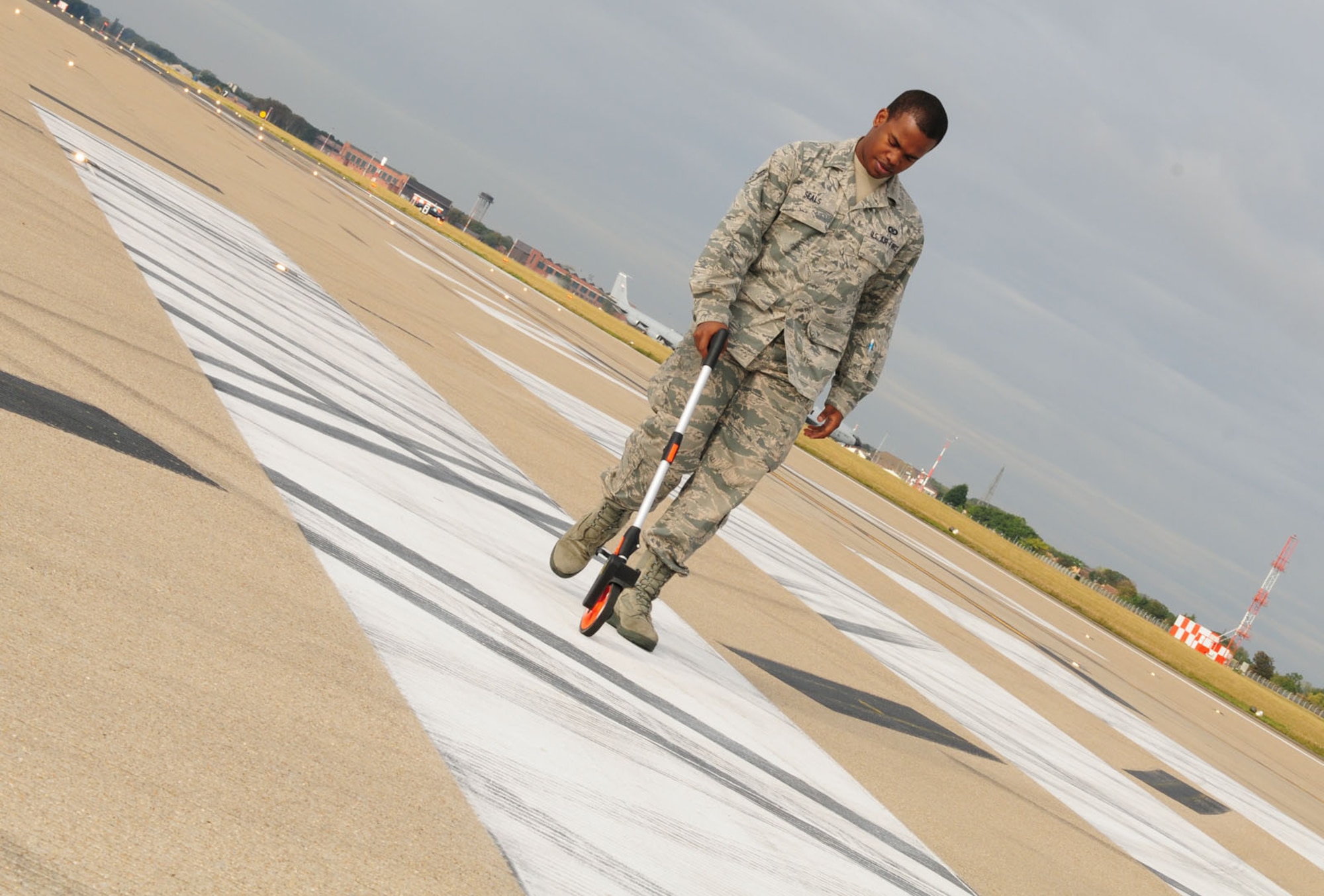 RAF MILDENHALL, England -- Airman 1st Class James Seals, 100th Operations Support Squadron Airfield Management, measures airfield markings to ensure they are in compliance with U.S. Air Forces in Europe standards Oct. 12, 2011. Airfield management personnel perform daily inspections of the airfield to ensure a safe operating environment for aircraft; checking markings, lighting, pavements, signs and access roads, in addition to checking for obstructions on the runway or around the airfield. (U.S. Air Force photo/Karen Abeyasekere)