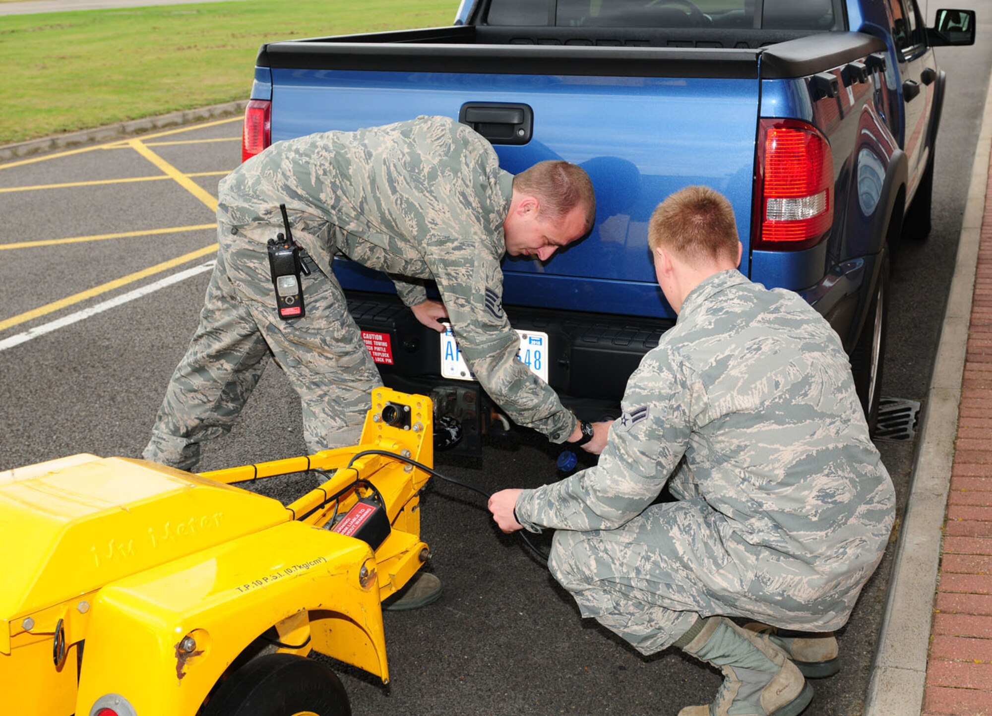 RAF MILDENHALL, England -- Staff Sgt. Robert Grotefend and Airman 1st Class Caleb Johnson, both 100th Operations Support Squadron Airfield Manangement, hook up a Mu-meter to a truck Oct. 11, 2011, near the flightline here. Aircraft management personnel use the equipment to determine the braking action on the runway -- vital information for aircraft coming in to land and preparing to take off. The Mu-meter is towed along and sends a reading to a laptop. The information is then logged and sent to aircrew in the form of ‘Notice to Airmen’ messages. (U.S. Air Force photo/Karen Abeyasekere)