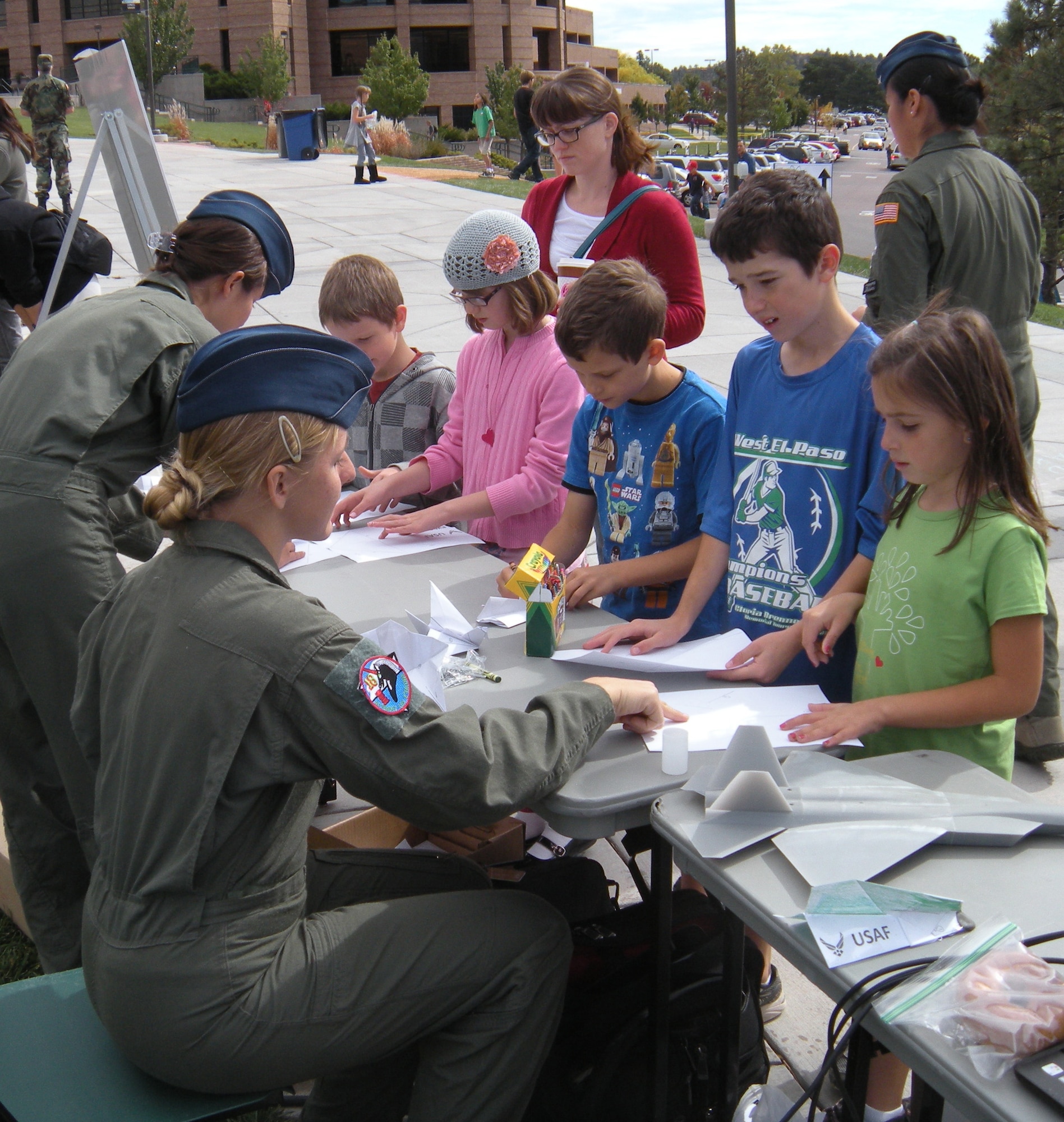 Cadets with the Air Force Academy's Science, Technology, Engineering and Mathematics club help children make paper airplanes at an aeronautics booth during the Cool Science Festival Hands-on Science Carnival Oct. 15, 2011, at the University of Colorado - Colorado Springs. Other Academy STEM booths featured models of future aircraft and a solid rocket demonstration. (U.S. Air Force photo)