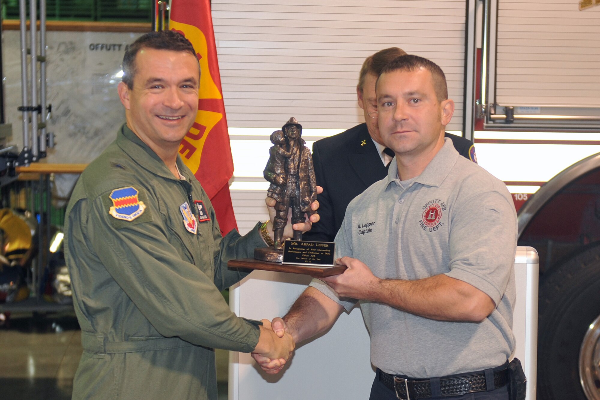 U.S. Air Force Brig. Gen. Donald J. Bacon, 55th Wing commander, presents the 2011 fire officer of the year award to Arpad Lepper at the Offutt Fire Station on Oct. 14. The award is given out annually during Fire Prevention Week. (U.S. Air Force photo by Jeff W. Gates/Released)