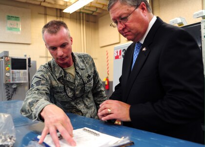 Master Sgt. Kevin Brackett shows Secretary of the Air Force Michael Donley press fit and slip fit bushings at the metals shop at Joint Base Charleston Oct. 18, 2011. The bushings are used to secure screws into fixtures. Donley is responsible for organizing, training, equipping and providing for the welfare of more than 334,000 active duty men and women, 176,000 members of the Air National Guard and the Air Force Reserve and 170,000 civilians and their families. Brackett is the 437th Maintenance Squadron metals shop, aircraft metals technology reserve section chief. (U.S. Air Force photo/Staff Sgt. Katie Gieratz)