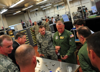 Team Charleston leadership view aircraft metals technology equipment with Secretary of the Air Force Michael Donley during his visit Joint Base Charleston Oct. 18, 2011. Donley is responsible for organizing, training, equipping and providing for the welfare of more than 334,000 active duty men and women, 176,000 members of the Air National Guard and the Air Force Reserve and 170,000 civilians and their families. The metals shop is responsible for designing, welding, fabricating, and creating machining parts for aerospace equipment. (U.S. Air Force photo/Staff Sgt. Katie Gieratz)