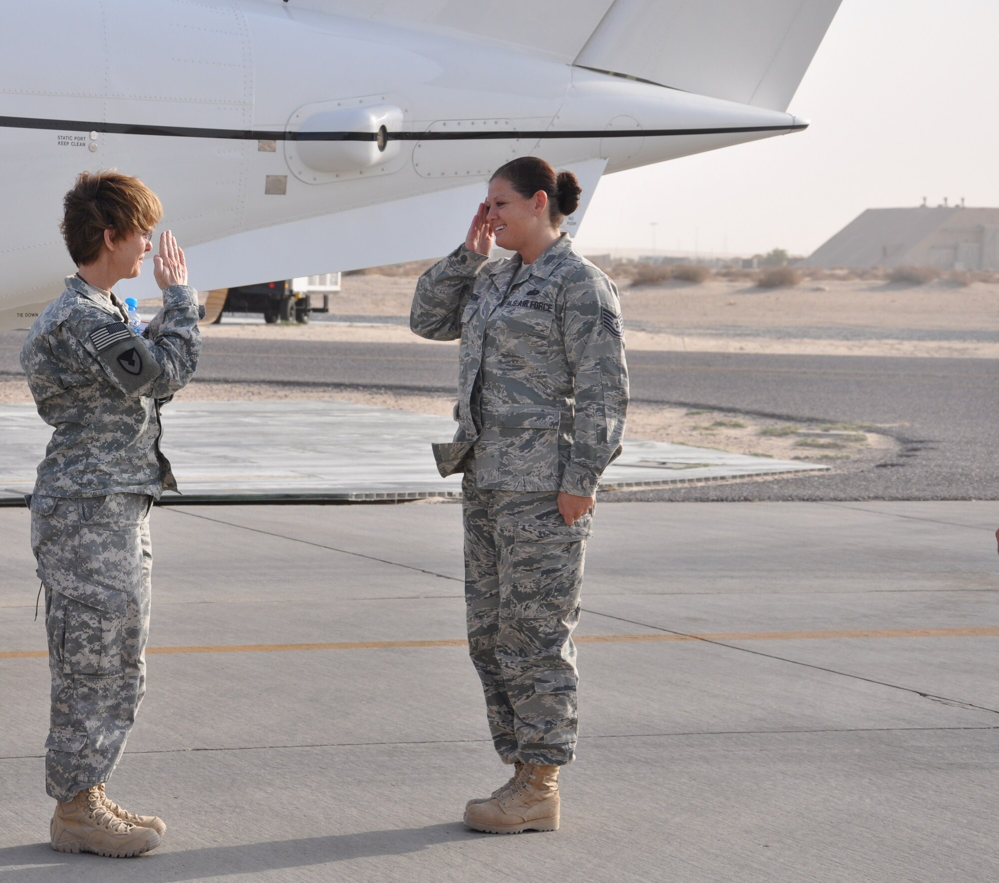 Technical Sgt. Tennille Benton, 386th Air Expeditionary Wing protocol NCO in charge, salutes Brigadier General Karen Ledoux, Commanding General, Army Materiel Command-Southwest Asia/G-4, United States Army Central, as she arrives to the 386th Air Expeditionary Wing Oct. 20 at an undisclosed location in Southwest Asia. (U.S. Air Force photo by Senior Airman Rachelle Elsea)