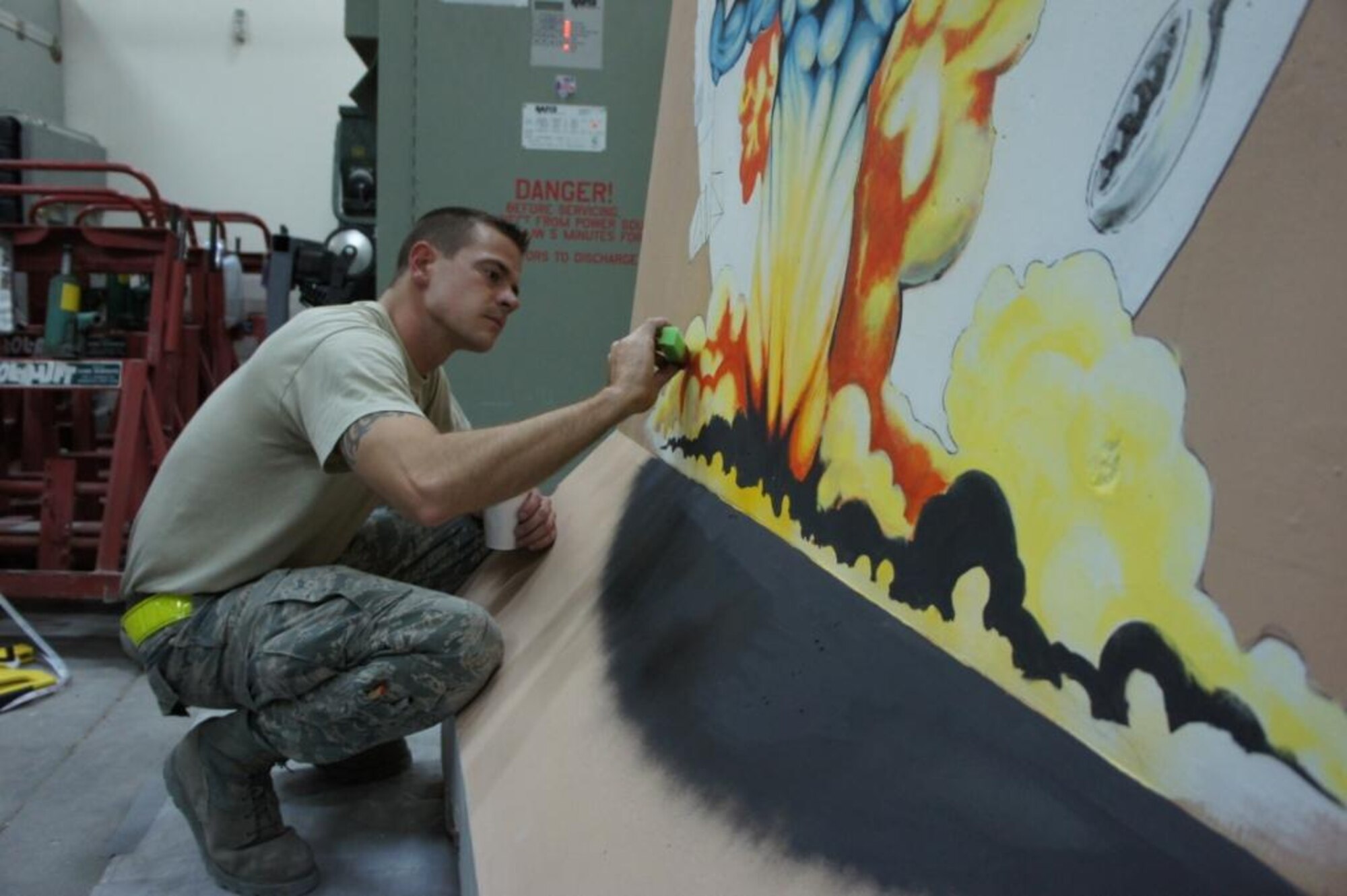 Tech. Sgt. Thomas Young, 379th Expeditionary Maintenance Squadron avionics production supervisor, applies paint with a sponge onto the 379 EMXS barrier, June 28, 2011, at an undisclosed location in Southwest Asia. Young has painted two barriers, to include a recent effort in front of the Independence Dining Facility, that depicts the Statue of Liberty and American flag. Young, a native of Orange, Calif., is deployed from Aviano Air Base, Italy. (Courtesy photo)