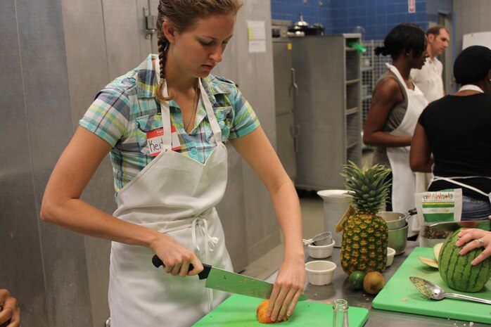 Senior Airman Keitha McCarthy slices a peach to make a watermelon carpaccio with fruit salsa Sept. 24 at the Culinary Institute of Charleston. More than 20 Airmen and their families participated in a free cooking class themed ‘Cooking Healthy on a Budget.’ The course was provided by the Joint Base Charleston Health and Wellness Center and taught by local chef Ken Immer. McCarthy is from the 437th Operations Group. Courtesy photo 