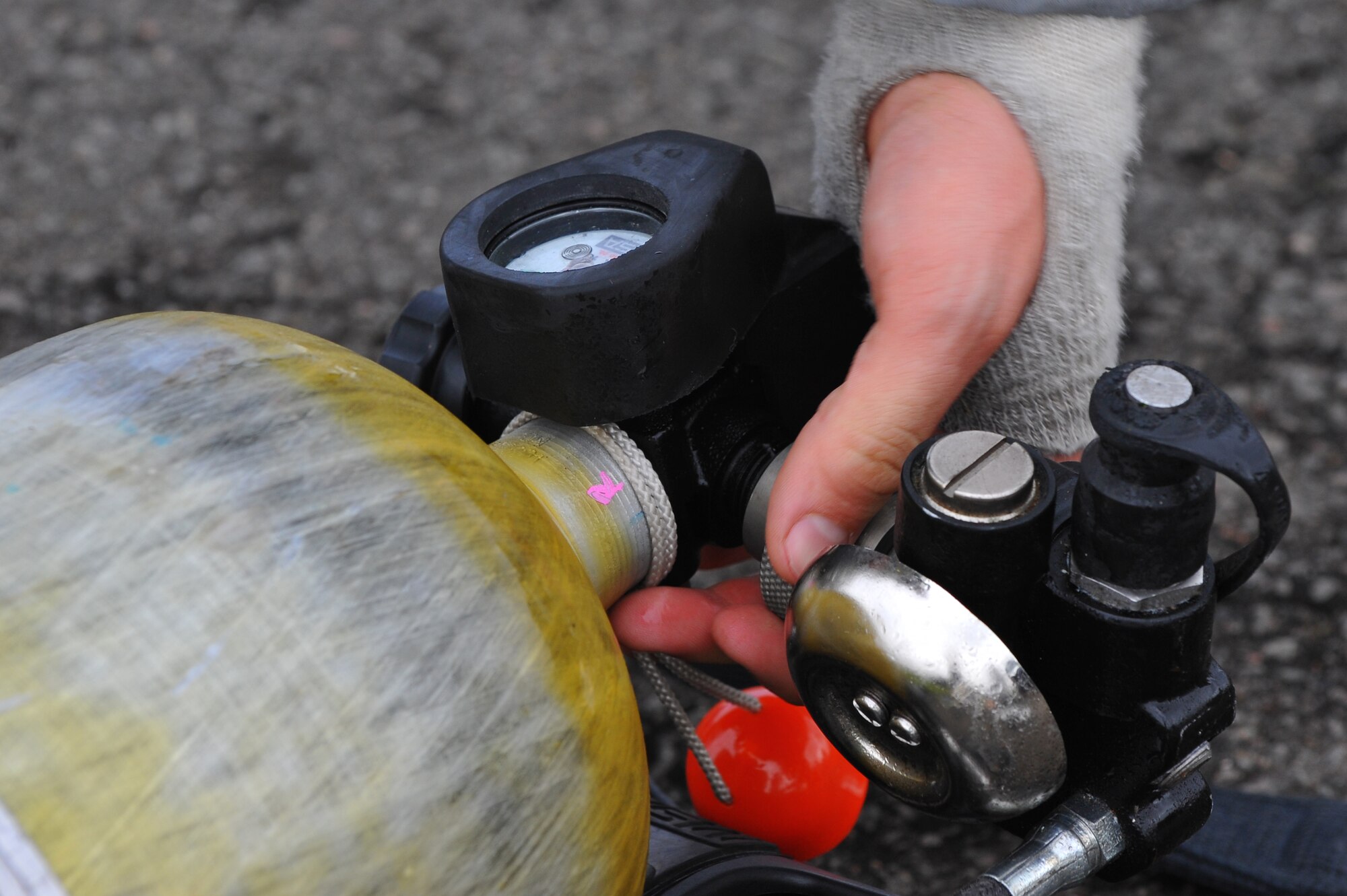 RAMSTEIN AIR BASE, Germany – A firefighter from the 52nd Civil Engineer Squadron Fire Protection Flight detaches an air line from an oxygen tank after live fire training here Oct. 19. Live fire training is mandatory for firefighters to complete twice a year. The training ensures firefighters are able to perform required core tasks in the event of an aircraft fire to protect lives and U.S. government assets. (U.S. Air Force photo/Airman 1st Class Dillon Davis)