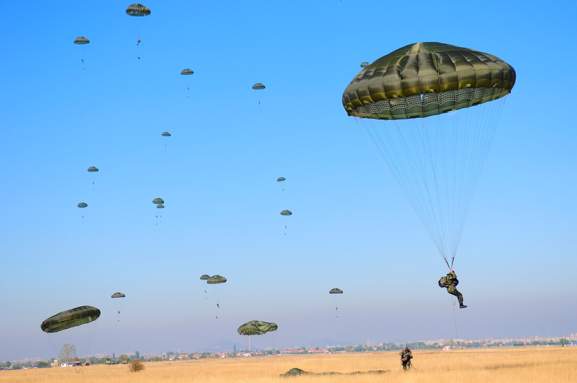 U.S. and Bulgarian Army paratroopers float to the ground after jumping from a C-130J aircraft during Operation Thracian Fall 2011, Oct. 19, 2011 in Plovdiv, Bulgaria. OTF11 is off-station training designed to enhance interoperability between U.S. and Bulgarian Air Forces as well as build partnerships with paratroopers from both. (U.S. Air Force photo by Staff Sgt. Travis Edwards)