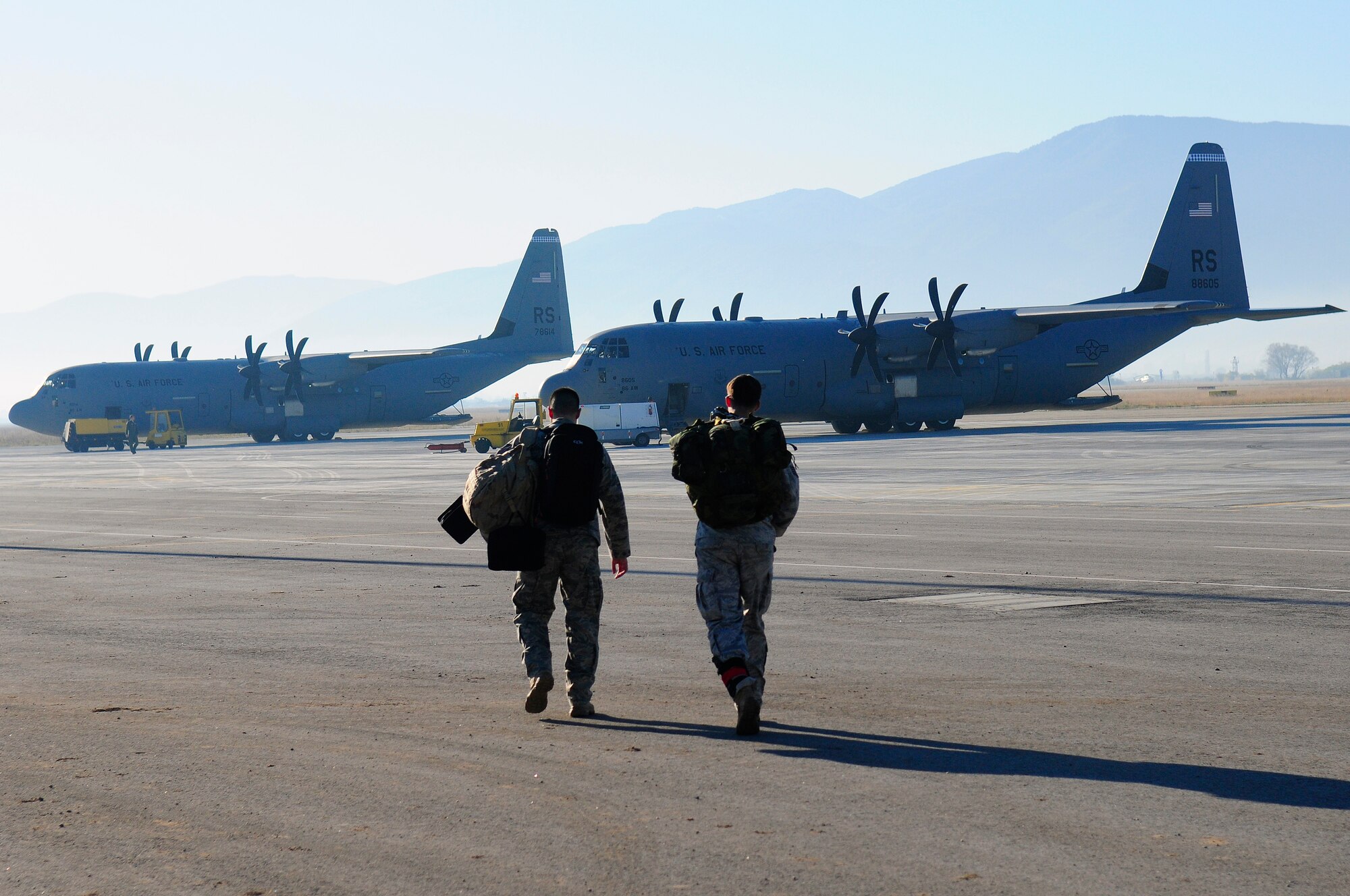 Staff Sgt. Nick Hurst, Operation Thracian Fall jumpmaster and Senior Airman Stephen J. Otero, 86th Airlift Wing photojournalist step to a C-130J Super Hercules in preparation for the morning personnel jump during Operation Thracian Fall 2011 at Plovdiv, Bulgaira, Oct. 19, 2011. The photojournalist was on-hand during OTF11 to document air and ground operations(U.S. Air Force photo by Staff Sgt. Travis Edwards)