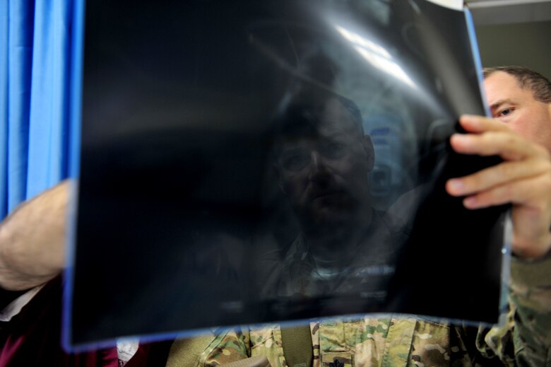 Lt. Col. Derrick Willsey looks at a lung X-ray of Roquia, an Afghan child, Oct. 10, 2011. Willsey is part of the Special Operations Surgical Team, deployed from the 1st Special Operations Support Squadron at Hurlburt Field, Fla.  The SOST team provides medicine to disadvantaged people, provides direct patient care, and builds relationships with local doctors. (U.S. Air Force Photo/SrA Tyler Placie)