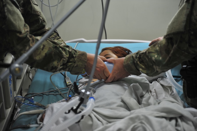 Lt. Col. Derrick Willsey (left) and Maj. Marion Foreman breathe for Roquia, an Afghan child, Oct. 10, 2011. Willsey is part of the Special Operations Surgical Team and is deployed from Hurlburt Field, Fla.  The SOST team provides medicine to disadvantaged people, provides direct patient care, and build relationships with local doctors. Foreman is a critical care nurse with the SOST, also deployed from Hurlburt Field. (U.S. Air Force Photo/SrA Tyler Placie)