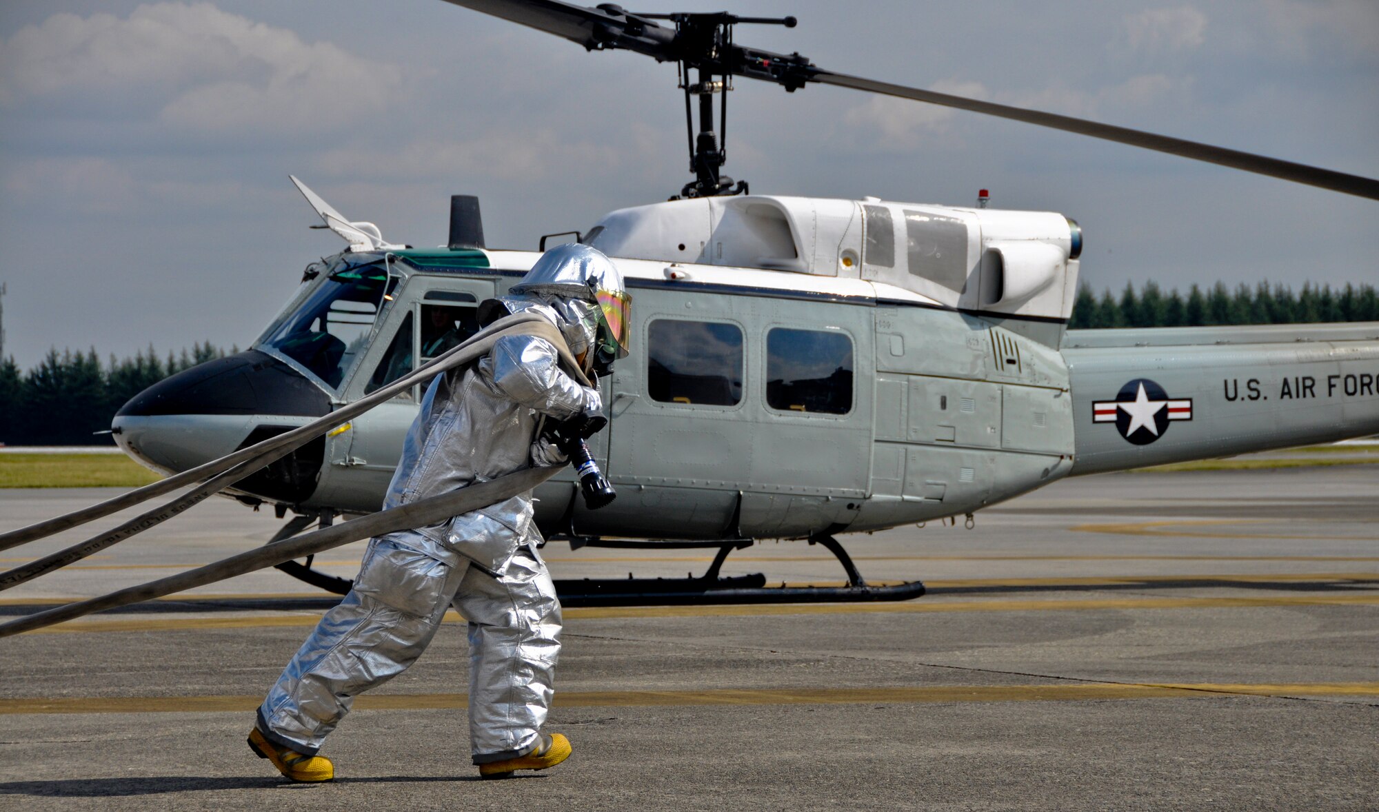 YOKOTA AIR BASE, Japan -- A firefighter from the 374th Civil Engineer Squadron unravels a fire hose at Yokota Air Base, Japan, Oct. 18, 2011. The 374th CES firefighters train regularly for aircraft fire responses. (U.S. Air Force photo/Airman John D. Partlow)