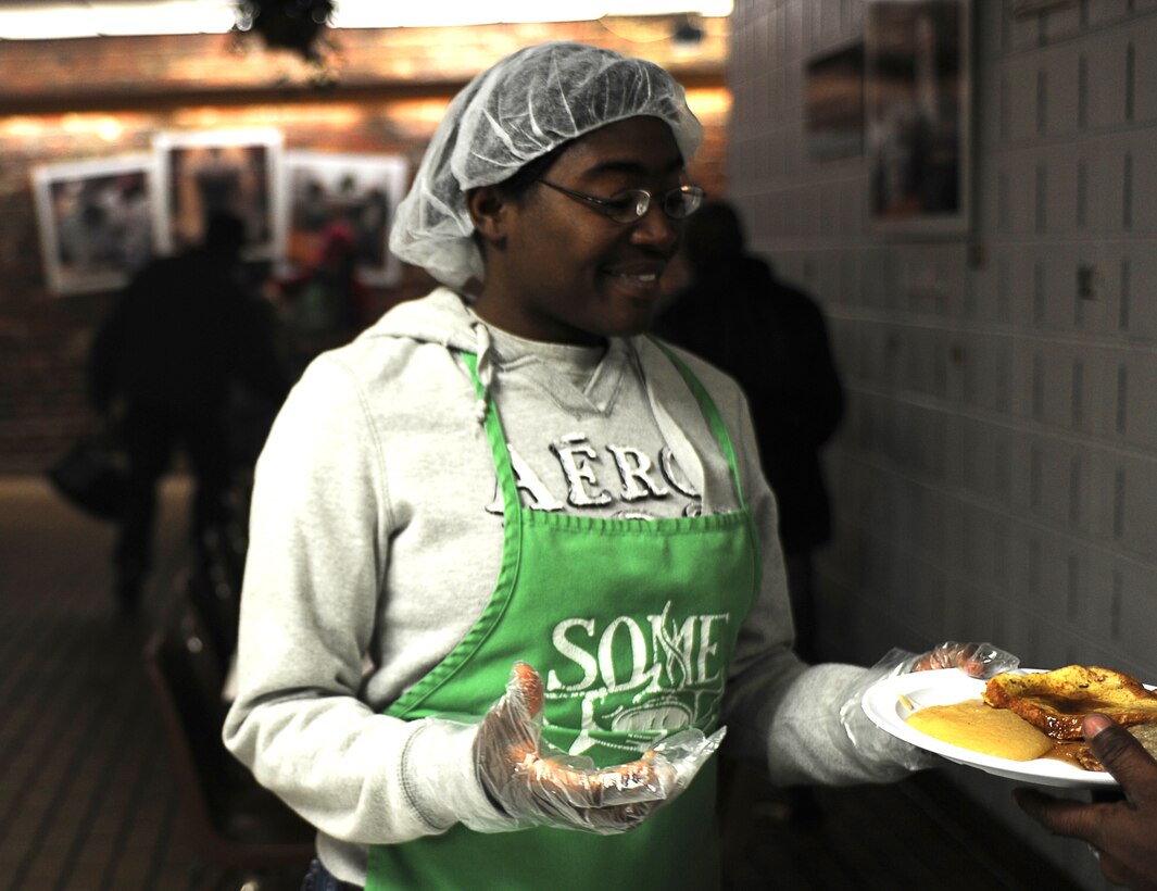 Gunnery Sgt. Crystal Holmes, United States Marine Band administrative chief, hands a plate of food to a homeless person during a So Others Might Eat volunteer event in northwest Washington, D.C., Oct. 20, 2011. Fifteen Marines from Marine Barracks Washington volunteered to assist the SOME staff in feeding homeless men and women from the Nation's capitol region.