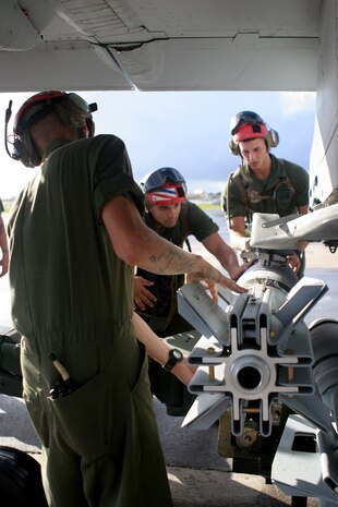 Sgt. Ian S. Wheeler (foreground), Pfc. Greg T. Morris (center) and Lance Cpl. Pawel Jamiolkowski (right), Marine Fighter Attack Squadron 115 aviation ordnance technicians, work to maneuver a bomb onto the wing of a F/A-18 Hornet on the flightline here, Oct. 20, during an air-to-ground ordnance exercise. Approximately 43,000 pounds of ordnance was dropped over the week.