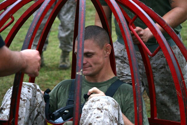 Staff Sgt. David B. Umoren, Marine Wing Support Squadron 171 motor transprtation maintnence chief, attempts to crawl forward while Master Sgt. Shelly D. Bothwell Jr. a Marine Aviation Logistics Squadron 12 aviation supply specialist, pulls him backward during a game of tug-of-war, which was part of the Gladiatior Challenge at Penny Lake here Oct. 21. Four units competed in different challanges held throughout the year, Headquarters and Headquarters Squadron, Combat Logistics Company 36, MWSS-171, and Marine Aircraft Group 12.