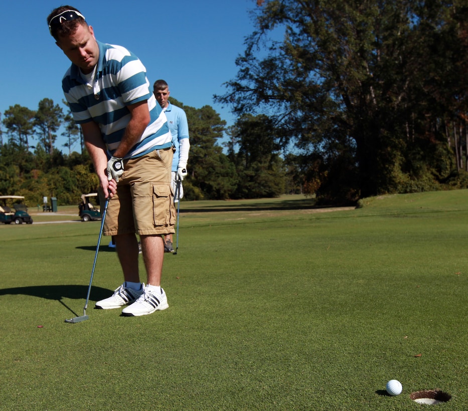 Corporal Mark B. Baker, staff secretary, Headquarters Battalion, 2nd Marine Division, watches his ball roll towards the hole after a putt during a golf tournament aboard Marine Corps Base Camp Lejeune, N.C., Oct. 21, 2011. The tournament was held to help raise money for their upcoming Marine Corps Ball and gave the Marines a day to relax and play a game of golf.