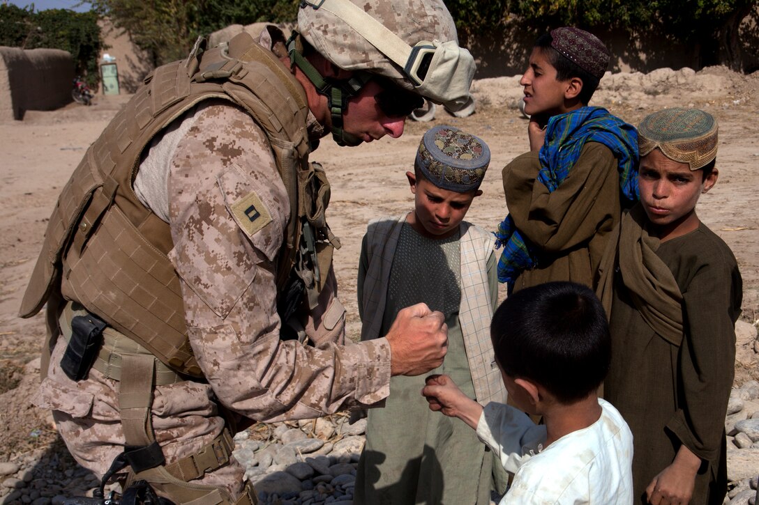 Capt. Michael Gagnon teaches Afghan children how to fist bump in the Helmand River valley of southwestern Afghanistan, Oct. 21. Gagnon, a native of Oxford, Mass., commands a team of roughly 20 men dubbed “Task Force Nomad.” Over the next several weeks, the task force, a subset of Marine Wing Support Squadron 371, will construct or improve helicopter landing zones along the Helmand River valley in southwestern Afghanistan.