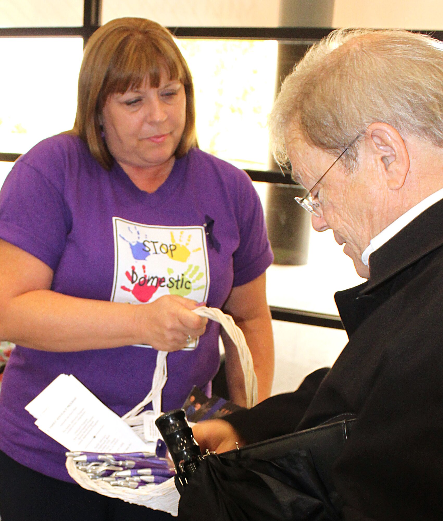 Elaine Estacio, Family Advocacy Outreach Manager, 95th Medical Group, passes out information and signs of support for the Domestic Violence Awareness Campaign here Oct. 5. (U.S. Air Force photo by Meredith Mingledorff)