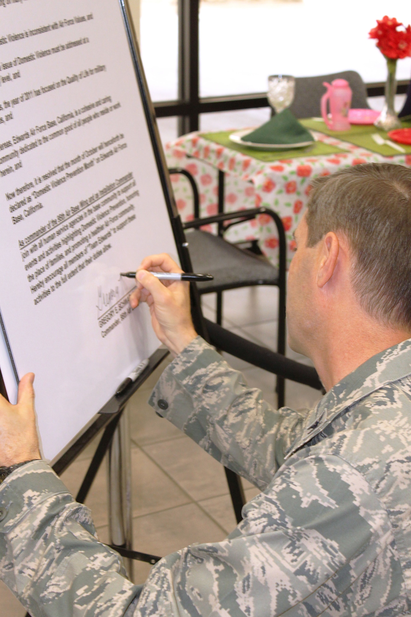 Col. Gregory Schwab signs a proclamation at 95th Air Base Wing Headquarters here Oct. 5 declaring October "Domestic Violence Awareness Month" at Edwards AFB. (U.S. Air Force photo by Meredith Mingledorff) 