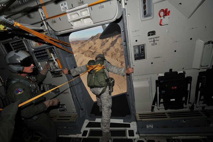 From left, U.S. Air Force Senior Master Sgt. David Kist, 97th Airlift Squadron aircraft loadmaster superintendent from McCord Air Force Base, Wash., looks on as U.S. Air Force Tech. Sgt. Mitchell Romag, 820th RED HORSE airborne flight jumpmaster, takes a closer look at the landing zone from a C-17 Globemaster III during a jump mission Oct. 15, 2011, at Nellis Air Force Base, Nev.  820th RED HORSE Airmen perform airdrop missions to stay current on training and certifications, which enables them to perform jump missions and operate their own drop zones. (U.S. Air Force photo by Senior Master Sgt. Kevin Gruenwald/Released)