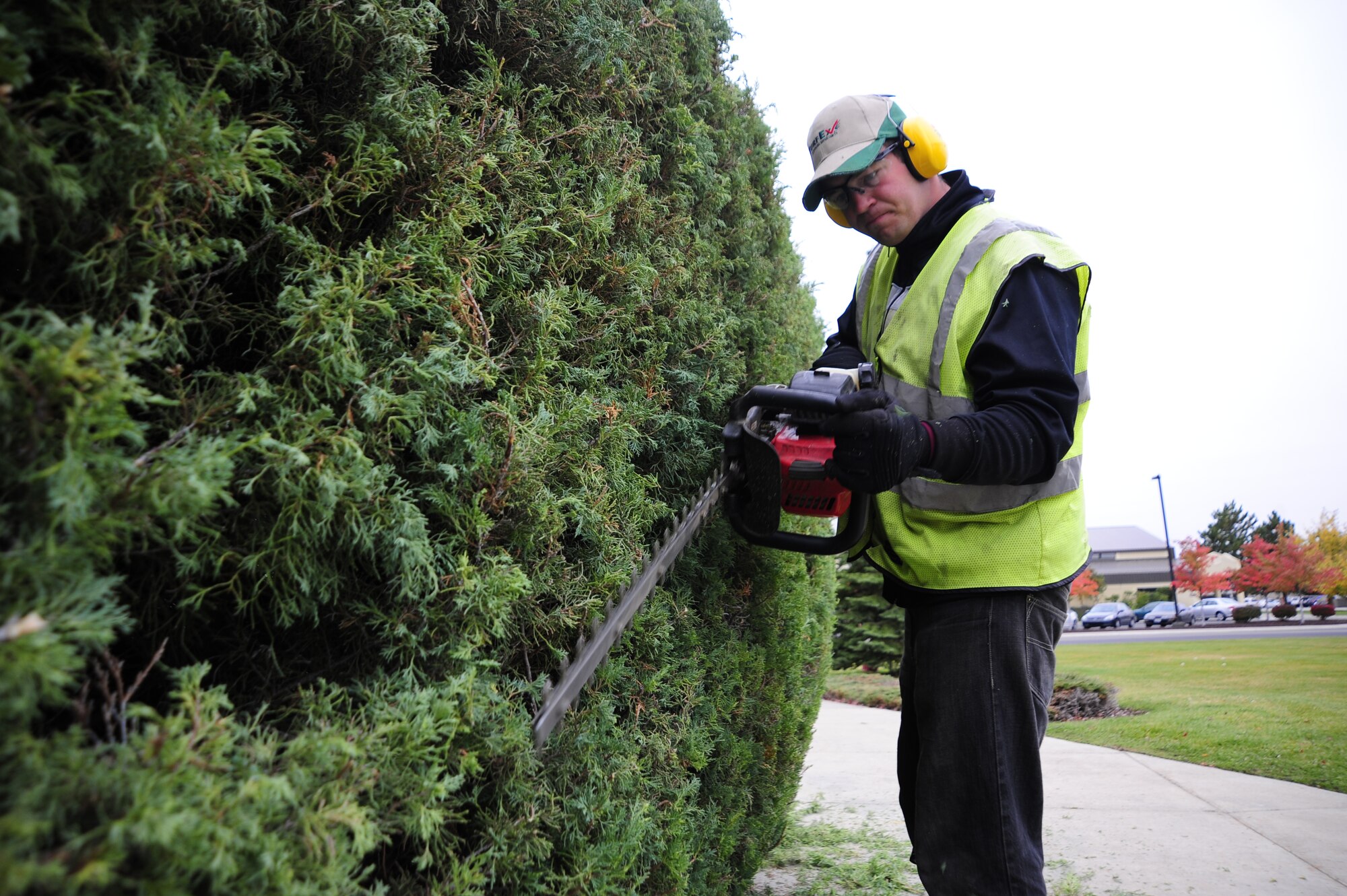 Adam Joseph Tomcho, Skils’kin grounds maintenance worker, uses a hedge trimmer to trim a bush in front of the Military Personnel Flight building Oct. 14. Adam has been with Skils’kin for three years and says that it has been good for him working with the company. (U.S. Air Force photo/Airman 1st Class Taylor Curry)