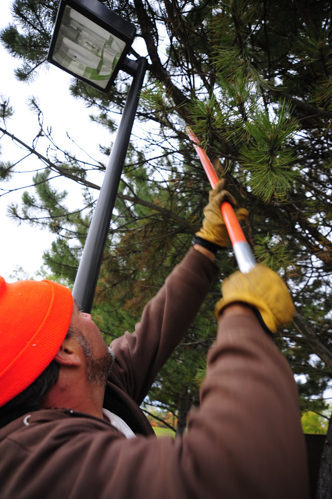 Shanagan Pinson, Skils’kin grounds maintenance worker, uses a pull-saw to chop down a tree limb on the dorm grounds Oct. 14. Skils’kin is a community-based, not-for-profit agency that works with national and local businesses. (U.S. Air Force photo/Airman 1st Class Taylor Curry)