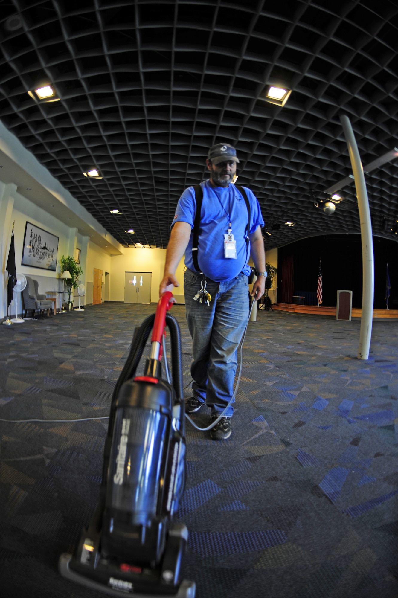 Edgar Schmidt, Skils’kin janitorial custodian, vacuums the floor in the ballroom at the Deel Community Center Oct. 13. Edgar has been an employee for Skils’kin for 13 years. He used to work for the grounds section of the company and said it is fun and very interesting. (U.S. Air Force photo/Airman 1st Class Taylor Curry)