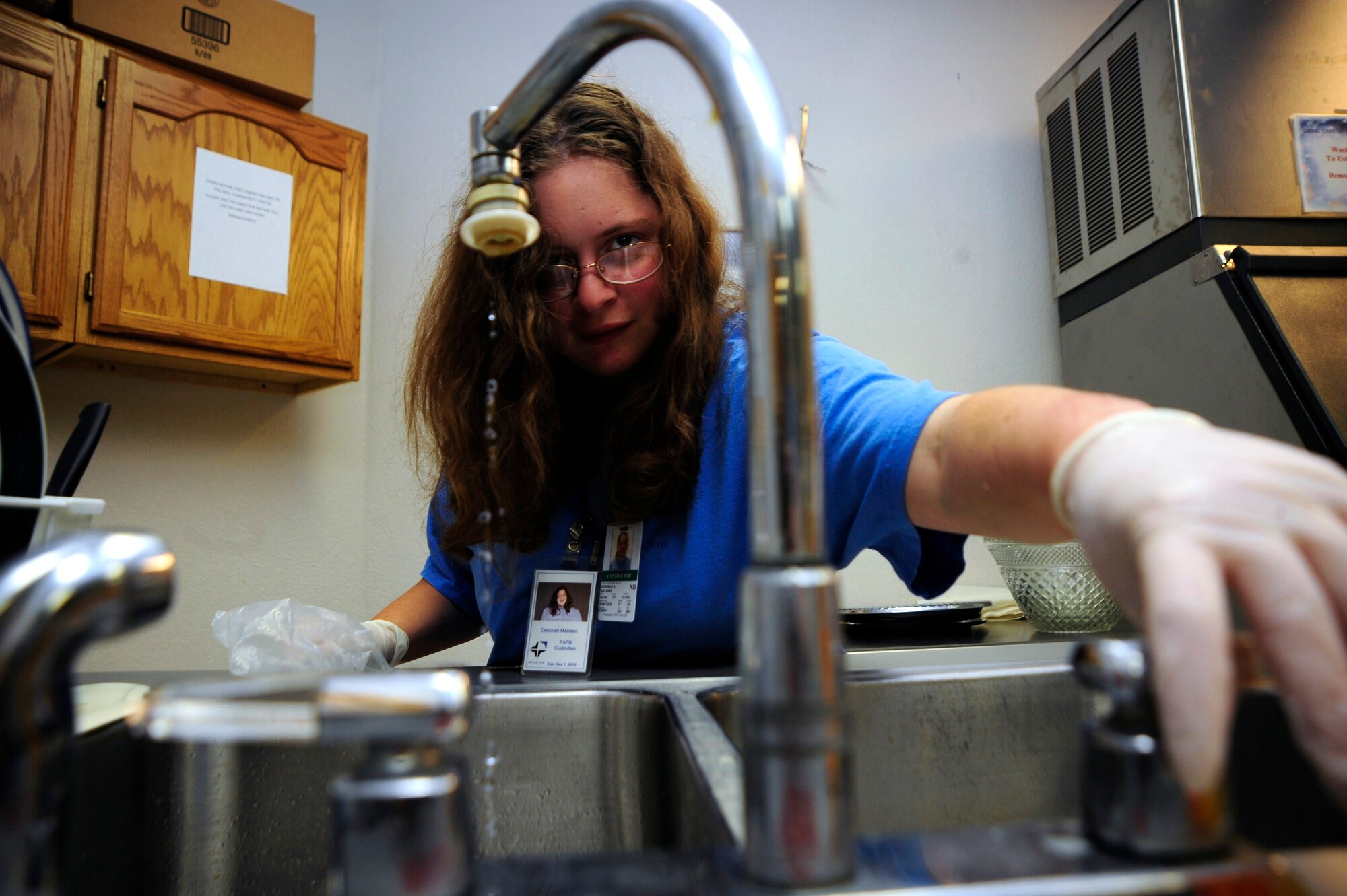 Deborah Melideo, Skils’kin janitorial custodian, cleans a kitchen sink at the Deel Community Center Oct. 13. Deborah has been an employee for Skils’kin for six years. The mission of Skils’kin is to provide effective support and services to people with disabilities. (U.S. Air Force photo/Airman 1st Class Taylor Curry)