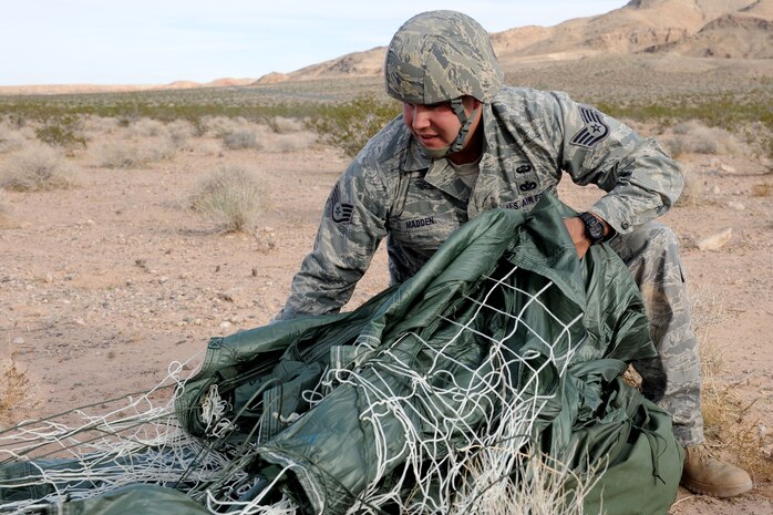 U.S. Air Force Staff Sgt. Jeffrey J. Madden, 820th RED HORSE Airborne Engineer Journeyman, gathers his parachute after a jump mission Oct. 14, 2011, at Nellis Air Force Base, Nev.  RED HORSE Airmen perform airdrop missions to stay current on training and certifications, enabling them to perform jump missions and operate their own drop zones. (U.S. Air Force photo by Staff Sgt. Taylor Worley/Released)