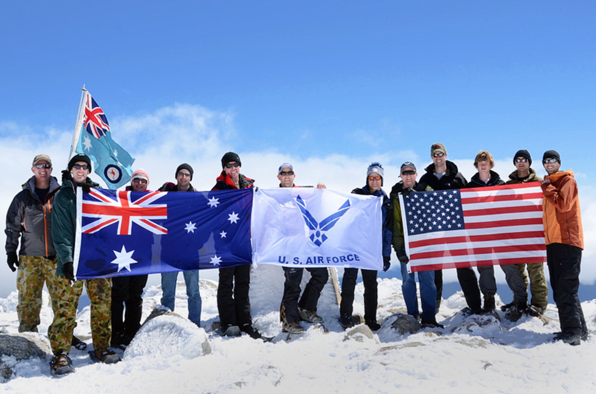 U.S. Air Force and Australian Defense Force members stand together displaying their flags on the summit of Australia?s highest peak, Mt. Kosciuszko, Oct. 3, 2011.  This was part of the U.S. Air Force 7 Summits Challenge, where a group of Airmen have made the goal of climbing to the top of each continent?s highest mountain. (Courtesy Photograph)